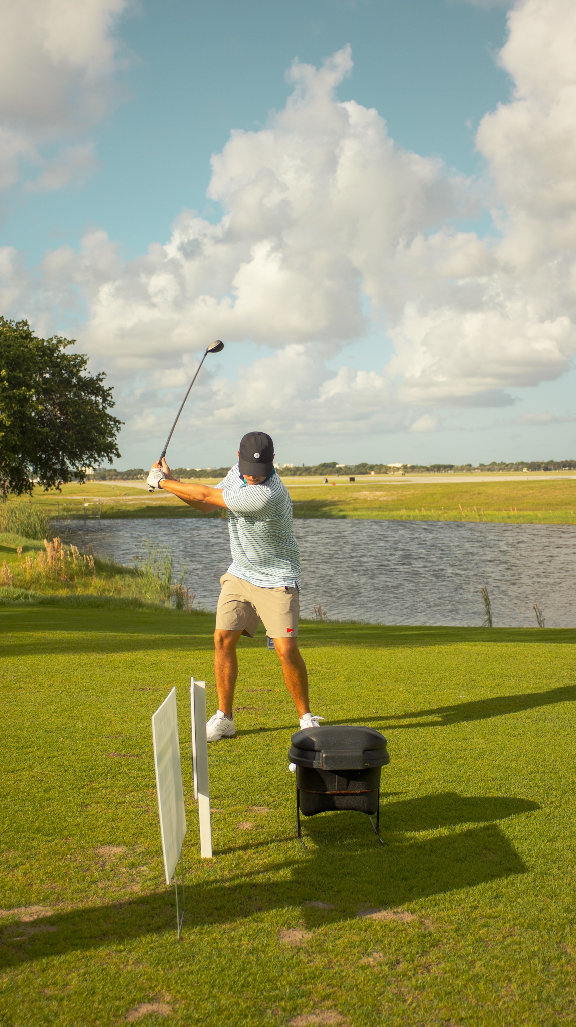 Player at the top of the backswing beside the water